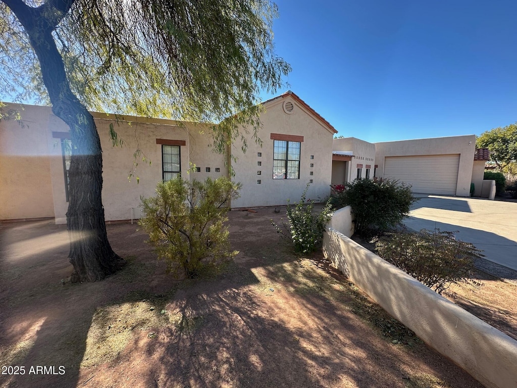 pueblo revival-style home with a garage