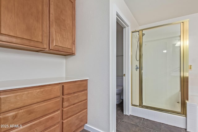 bathroom featuring a shower with shower door and toilet