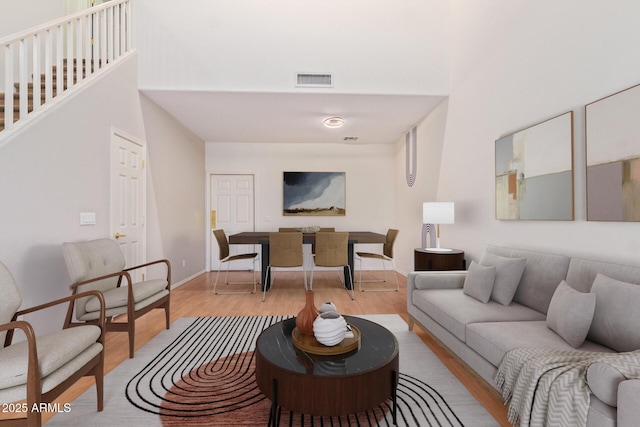 living room with light hardwood / wood-style flooring and a high ceiling