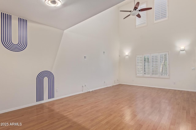 unfurnished room with ceiling fan, high vaulted ceiling, and wood-type flooring