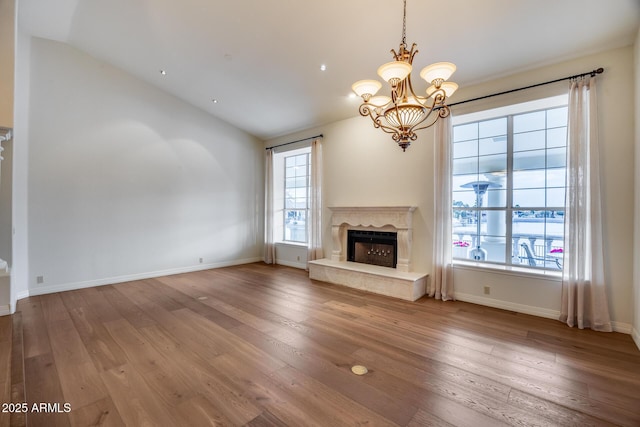 unfurnished living room featuring lofted ceiling, hardwood / wood-style floors, and a high end fireplace