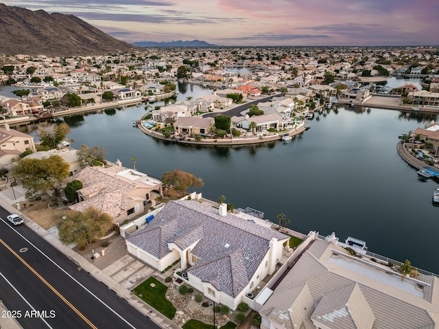 aerial view at dusk featuring a water view