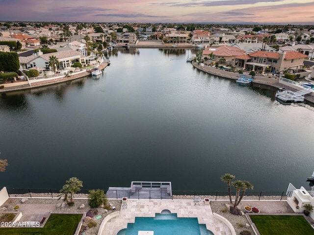 aerial view at dusk featuring a water view