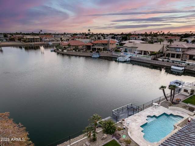 aerial view at dusk featuring a water view