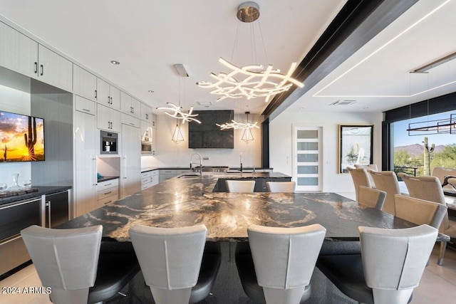 tiled dining area with sink and a notable chandelier