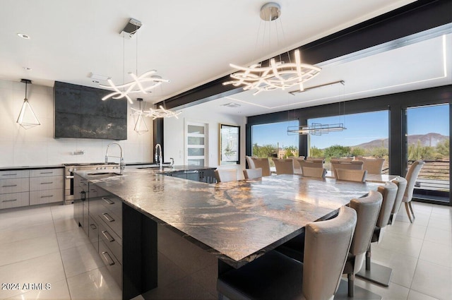 kitchen featuring tasteful backsplash, sink, a large island, decorative light fixtures, and a mountain view