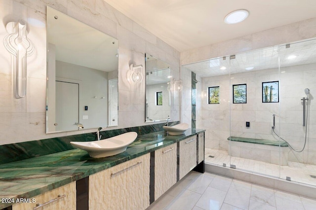 bathroom featuring vanity, a shower with shower door, and tile walls