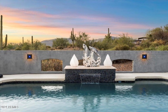 pool at dusk with a patio area