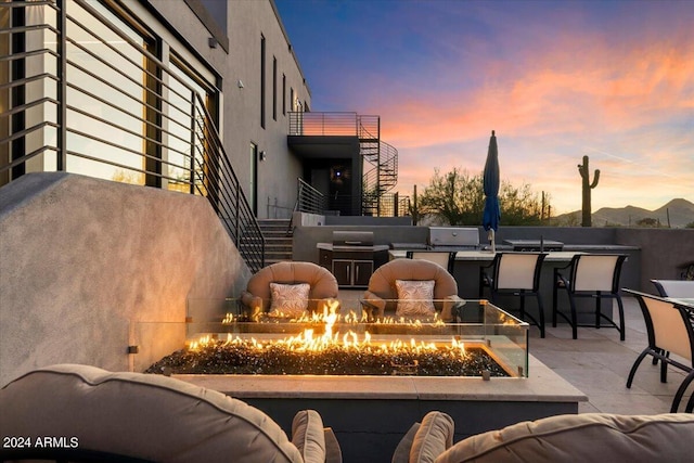 patio terrace at dusk featuring an outdoor fire pit