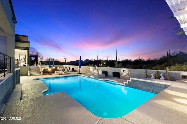 pool at dusk with a patio area