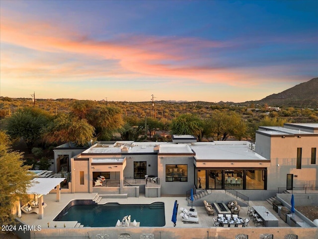 back house at dusk featuring a patio area