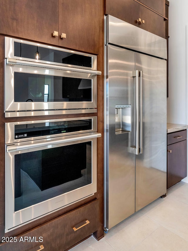 6727 N 9th Dr, Phoenix, AZ 85013 - kitchen with stainless steel appliances, light tile patterned floors, and dark brown cabinets