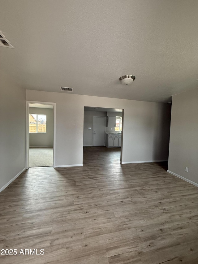 spare room with hardwood / wood-style flooring and a textured ceiling