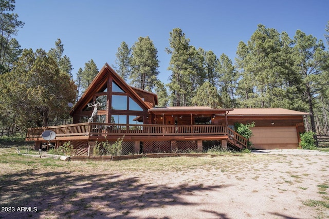 log cabin featuring a wooden deck and a garage