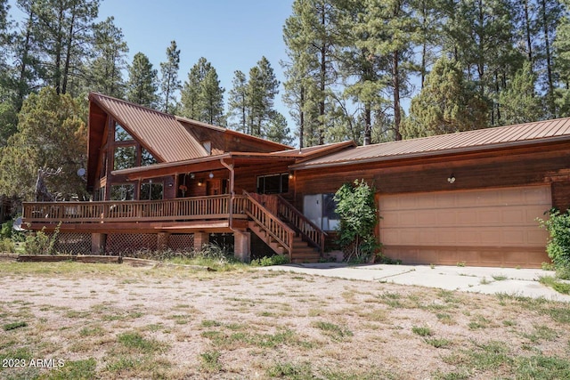 log cabin with a deck and a garage