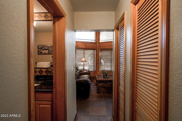 hallway featuring dark tile floors