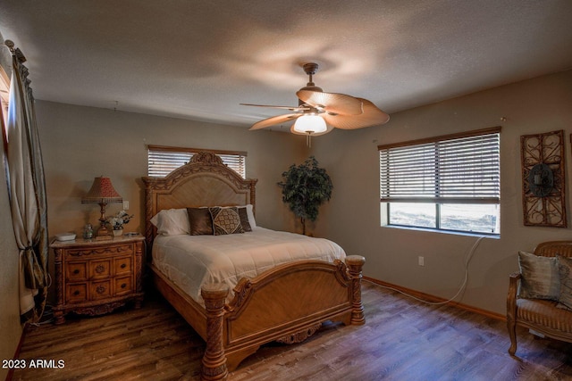 bedroom with a textured ceiling, ceiling fan, and hardwood / wood-style flooring