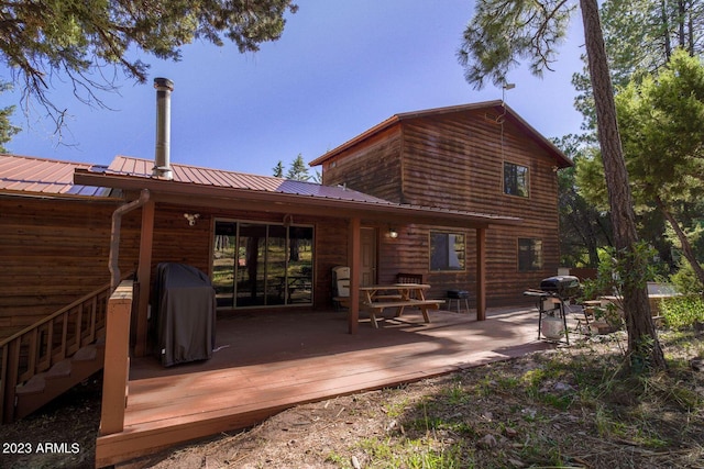 rear view of house featuring a wooden deck