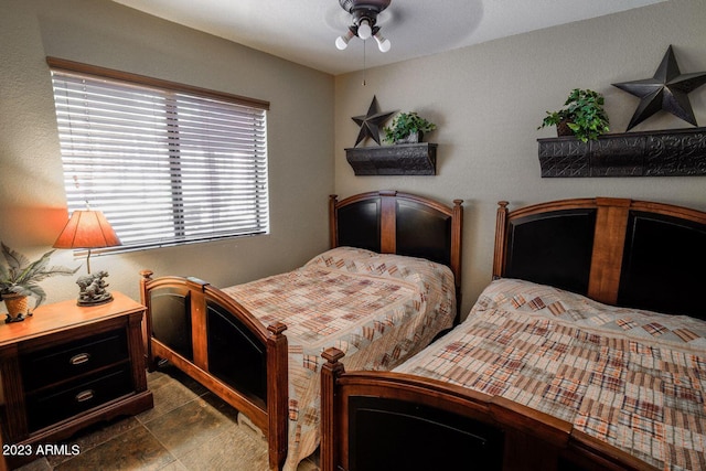 bedroom with dark tile flooring and ceiling fan