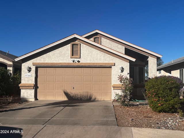 view of front of home featuring stucco siding, concrete driveway, and an attached garage