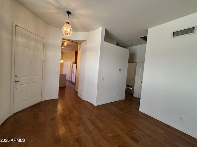 spare room featuring dark wood finished floors, baseboards, and visible vents