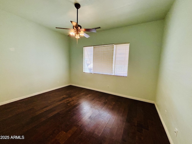 empty room featuring baseboards, dark wood-type flooring, and ceiling fan