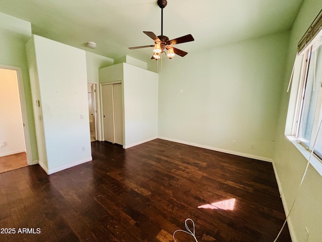 empty room with a ceiling fan, wood finished floors, and baseboards