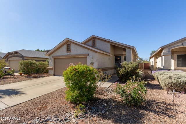 mid-century home featuring a garage, driveway, and stucco siding