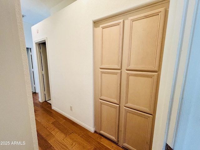 hall with baseboards and wood finished floors