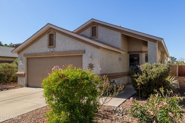 view of front of property with an attached garage, driveway, and stucco siding