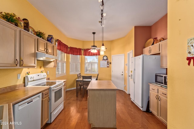 kitchen featuring under cabinet range hood, white appliances, hardwood / wood-style floors, and a center island