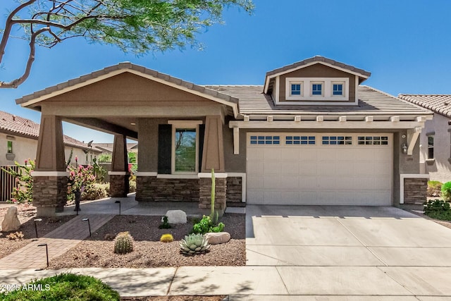 4898 N 206th Ln, Buckeye, AZ 85396 - view of front of home with stone siding, a tile roof, driveway, covered porch, and stucco siding