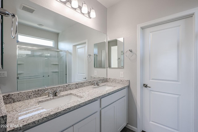 bathroom featuring vanity and a shower with shower door