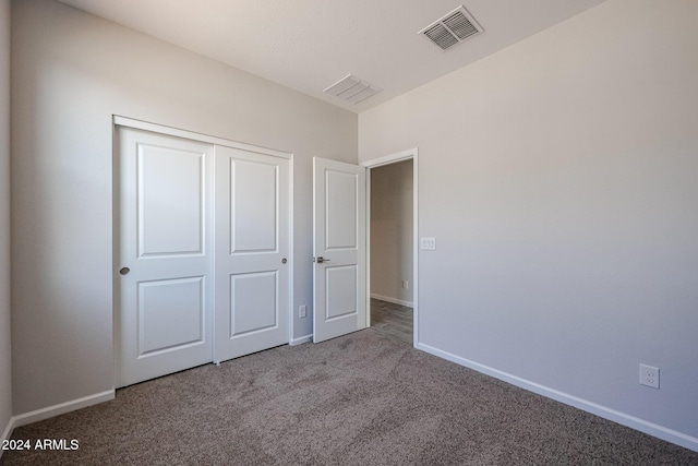 unfurnished bedroom featuring carpet and a closet