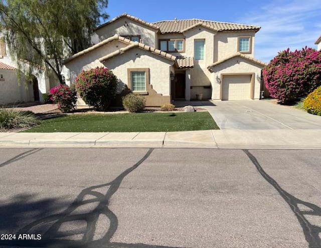 mediterranean / spanish house with a front yard and a garage