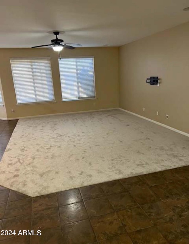 carpeted spare room with ceiling fan