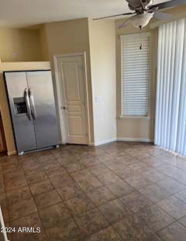 interior space featuring ceiling fan and stainless steel refrigerator with ice dispenser