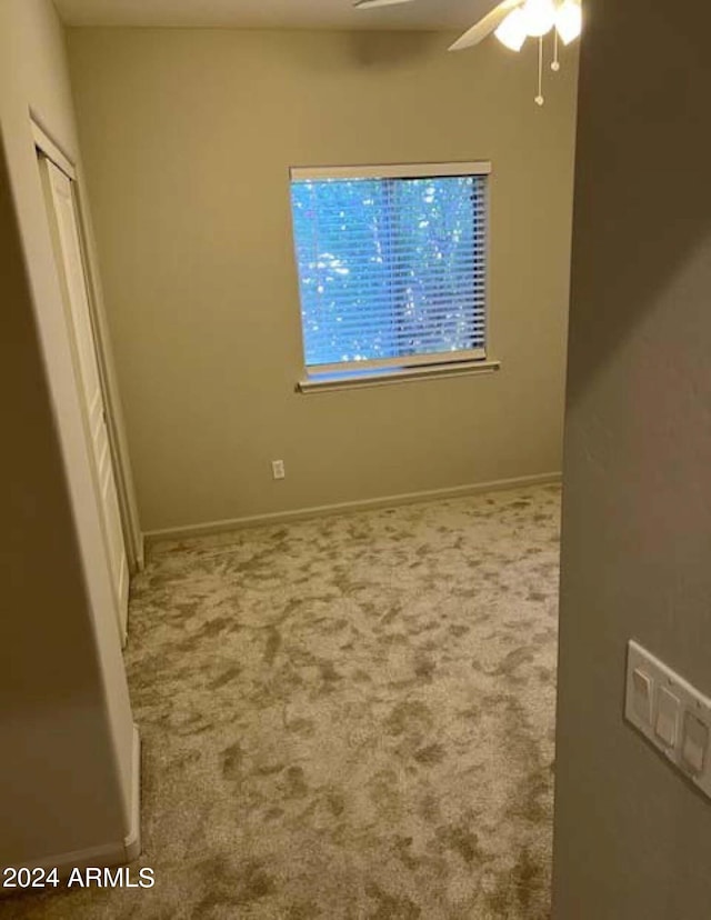 unfurnished room with ceiling fan and carpet