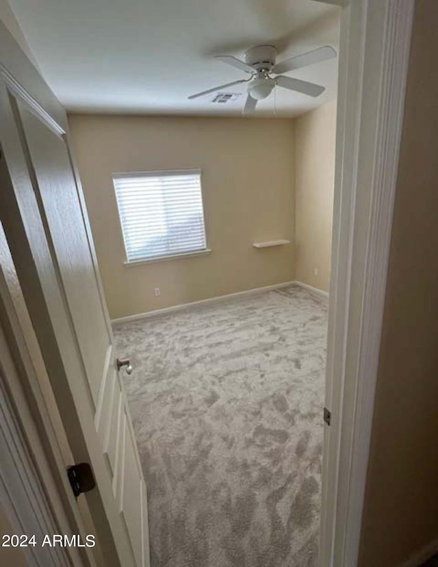 carpeted spare room with ceiling fan