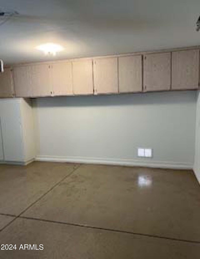 interior space featuring light brown cabinetry and concrete flooring