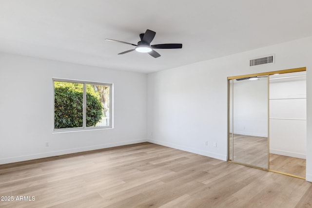 unfurnished bedroom featuring ceiling fan, a closet, and light hardwood / wood-style flooring