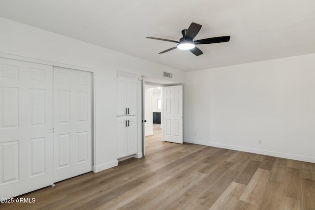 unfurnished bedroom featuring ceiling fan, a closet, and light wood-type flooring