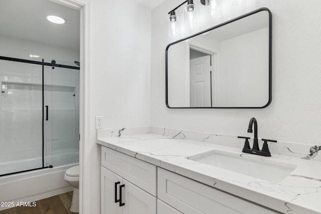 full bathroom with toilet, vanity, enclosed tub / shower combo, and hardwood / wood-style flooring