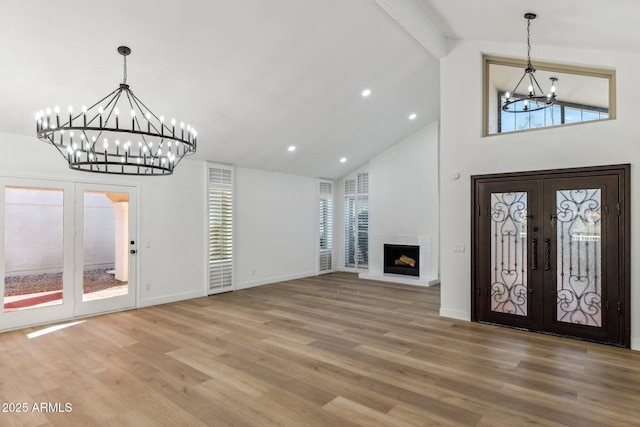 foyer entrance featuring beamed ceiling, hardwood / wood-style floors, a wealth of natural light, and french doors