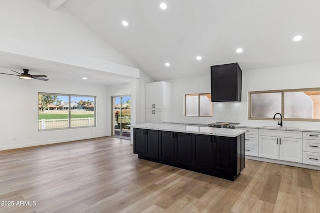 kitchen featuring ceiling fan, sink, light hardwood / wood-style flooring, a center island, and white cabinetry