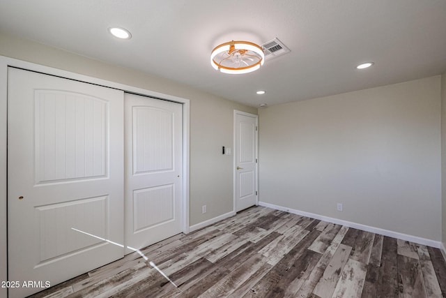 unfurnished bedroom featuring hardwood / wood-style floors and a closet