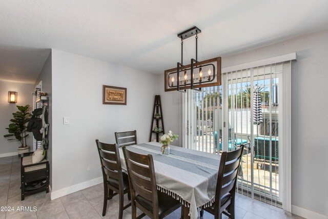 dining space featuring light tile patterned floors and a notable chandelier