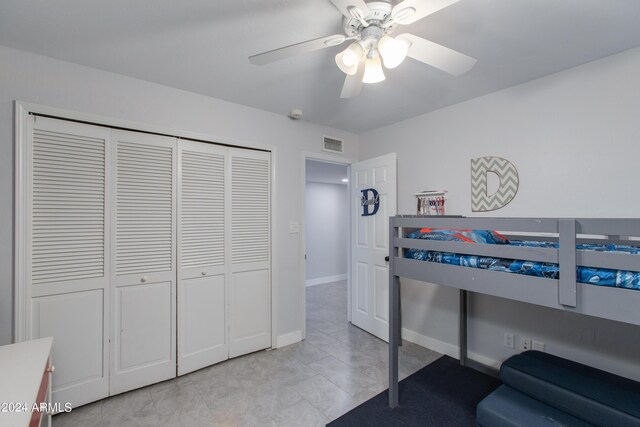 tiled bedroom featuring ceiling fan and a closet