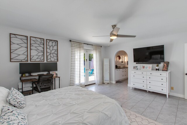 bedroom featuring ceiling fan, light tile patterned floors, access to outside, and ensuite bath