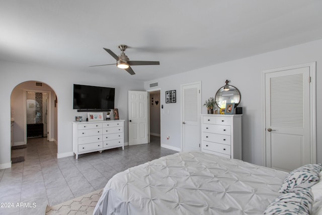 bedroom featuring multiple closets, ceiling fan, and light tile patterned flooring